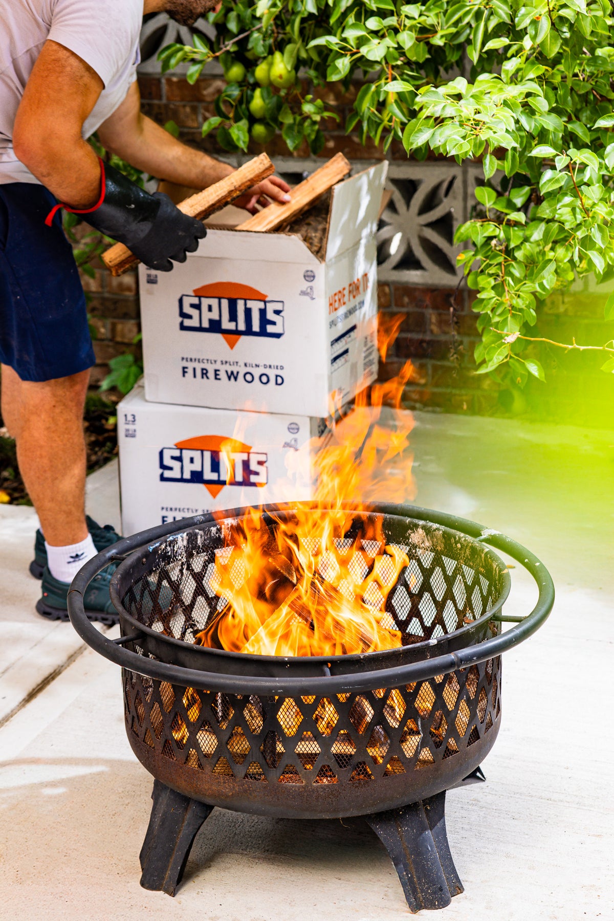 Adding SPLITS kiln-dried firewood to a backyard fire pit