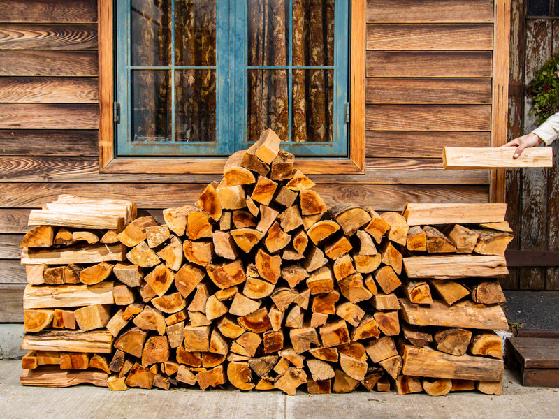 Heaping half face cord of kiln-dried firewood stacked on a firewood rack